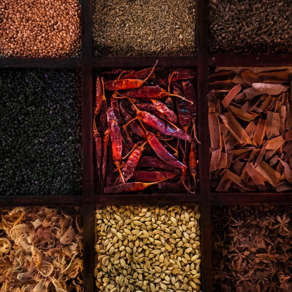 Assorted whole spices in a wooden spice box
